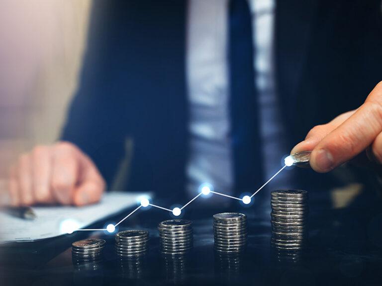 business-man-drawing-a-chart-with-coins-on-table-for-money-maximizing-concept-rockland-ma